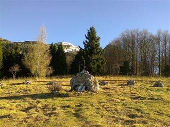 Alla nostra destra in basso vediamo i ruderi della Planina Golobar e dopo ulteriori svolte sbuchiamo  infine sul pianoro di Cez Utro, conosciuto nella Grande Guerra come Sella Golobar, dove troviamo un monumento partigiano.