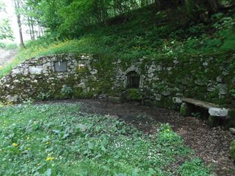 La carrareccia prosegue a mezzacosta lungo il versante occidentale del Colle di Mengore fino ad una fontanella con panca e targhe commemorative.