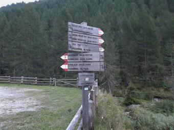 Dal centro del paese seguiamo quindi la strada che conduce nella Knuttental/Valle dei Dossi sino al grande parcheggio posto al termine del tratto transitabile ai mezzi motorizzati, dove troviamo  un cartello informativo con i principali sentieri della zon