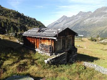 Un ultimo gradino roccioso ci conduce infine all'ampio pascolo della Sossenalm/M.ga dei Sassi, dove raggiungiamo l'edificio principale dopo aver guadato il rio omonimo su alcune grandi pietre opportunamente posizionate.