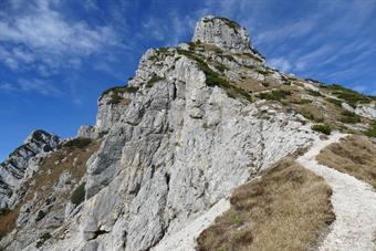 Nell’ultimo traverso che ci porta vero la forcelletta del monte Piz, tre grosse stalattiti di ghiaccio, appollaiate tra le nicchie delle balconate rocciose, pregano che il cielo s’annuvoli al più presto. Poi eccolo il Pizzocco! Con quella croce che intrav