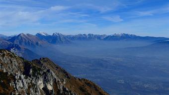 Ci fermiamo più in alto, ad osservare il panorama. La piana è uno stagno vitreo, dalla superficie opaca, quel vedo-nontivedo che t’affascina più d’ogni cielo terso. Dal Nevegal seguiamo i profili dell’abbracciosa cresta che diparte da Cima Manera, fino al